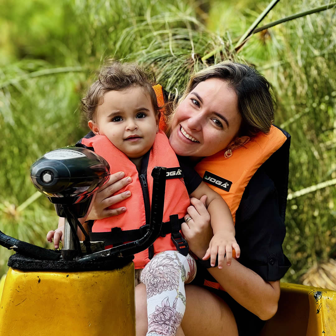 Mãe e filha andando de pedalinho em um lago, aproveitando o passeio juntas