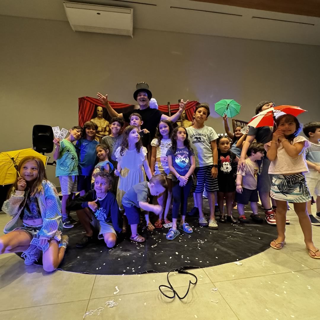 Crianças se divertindo enquanto assistem a um mágico realizando truques.