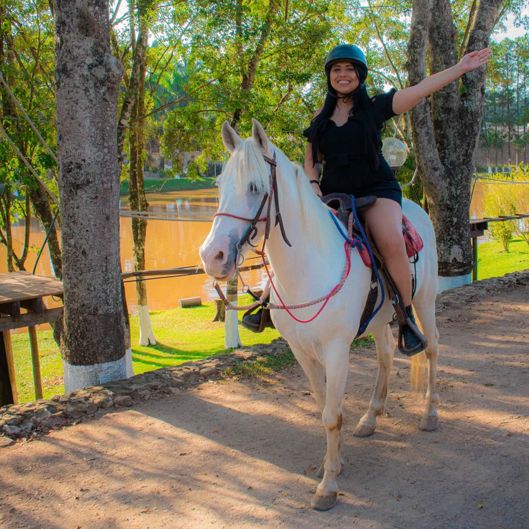 Mulher andando a cavalo em um ambiente ao ar livre