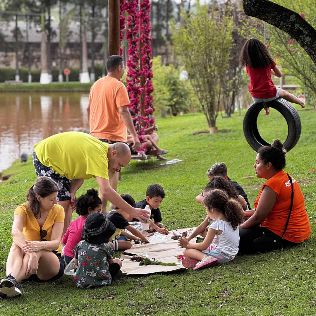 Recreador com uma família próximos a um lago em hotel fazenda, aproveitando momento ao ar livre.