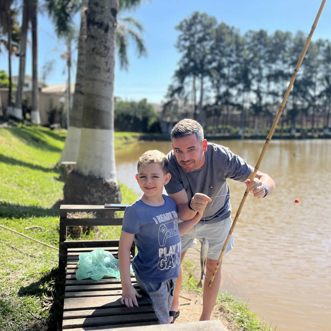 Pai e filho pescando em hotel fazenda