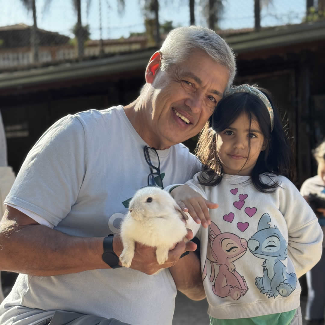 Pai e filha segurando um coelho na fazendinha do Park Hotel Modelo