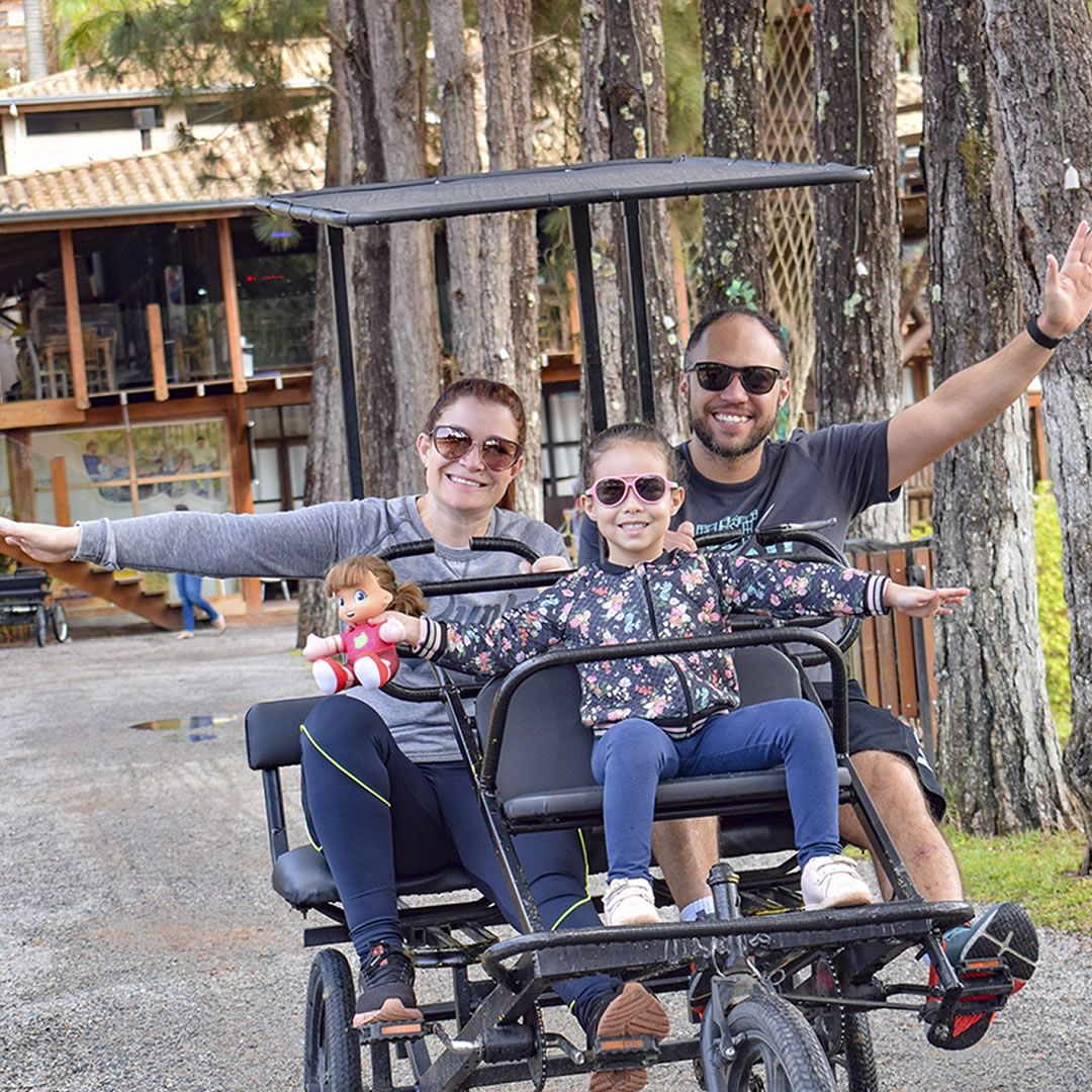 familia sorrindo quando andam no triciculo no Park Hotel Modelo
