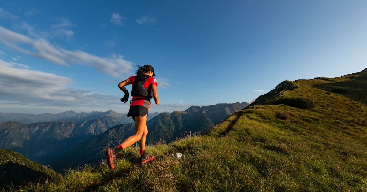 Mulher correndo no topo de uma montanha